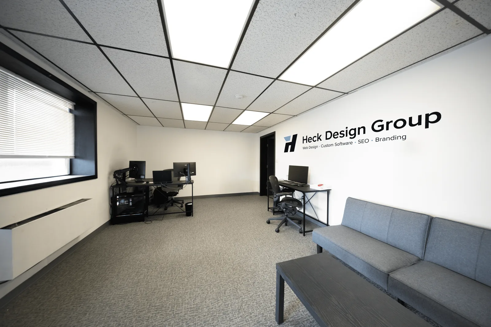 Heck Design Group studio reception area in Hooksett, NH with branded wall signage and design workstations
